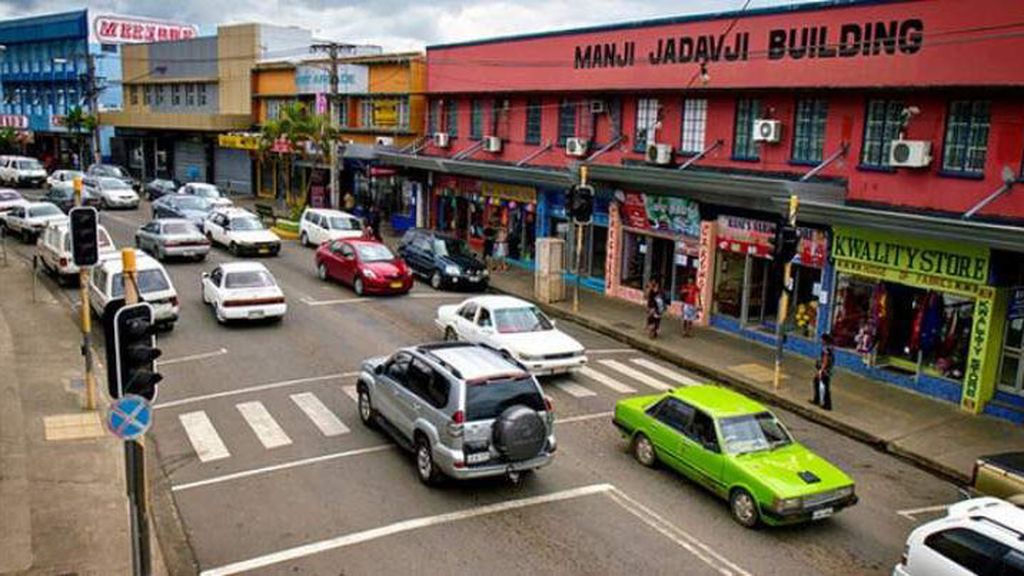 Bustling Nadi Town main street with vibrant shops and local vendors offering souvenirs and fresh fruits in Fiji.